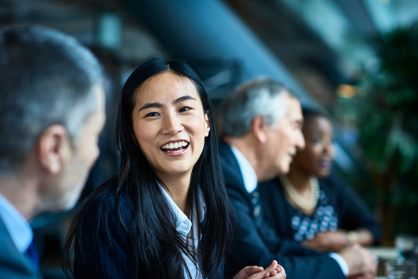 Close up portrait of Asian businesswoman, beside male senior coworker, smiling and laughing, respect, admiration