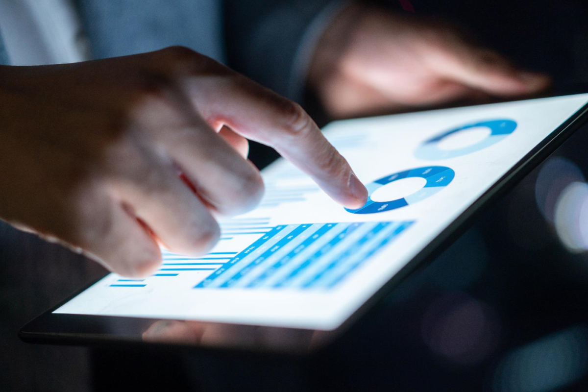 Person looking at a tablet with analytics on the screen